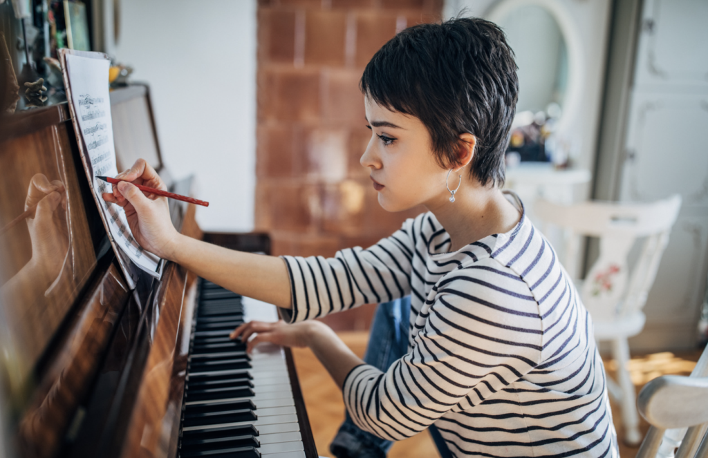 Young woman pianist composing music