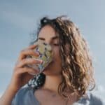 a woman drinking water from a glass