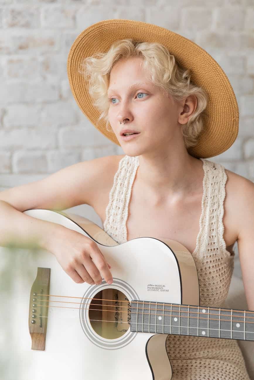 gorgeous young lady playing classic guitar and looking away pensively