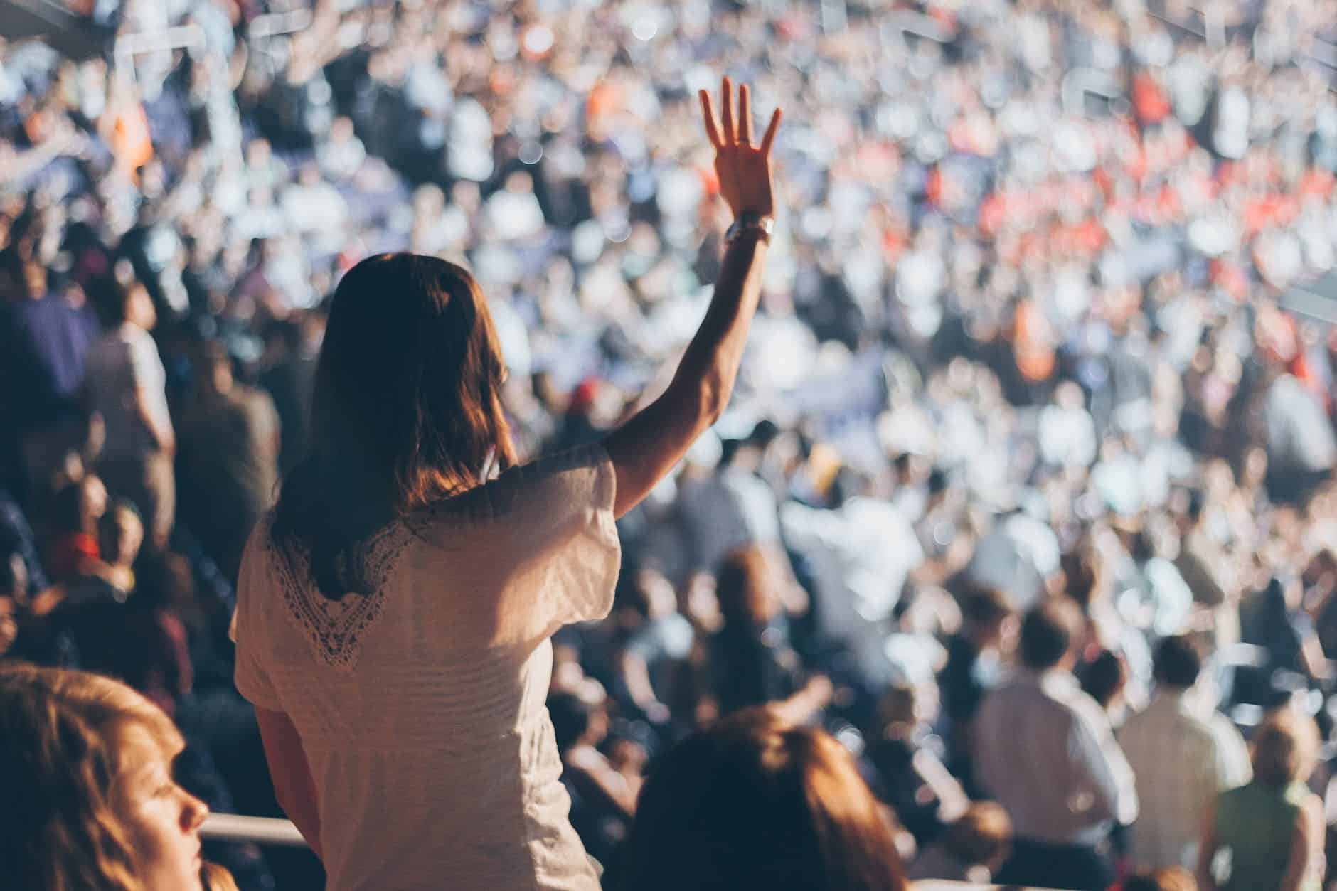 How To Engage An Audience During A Performance 31 woman with white shirt raising her right hand