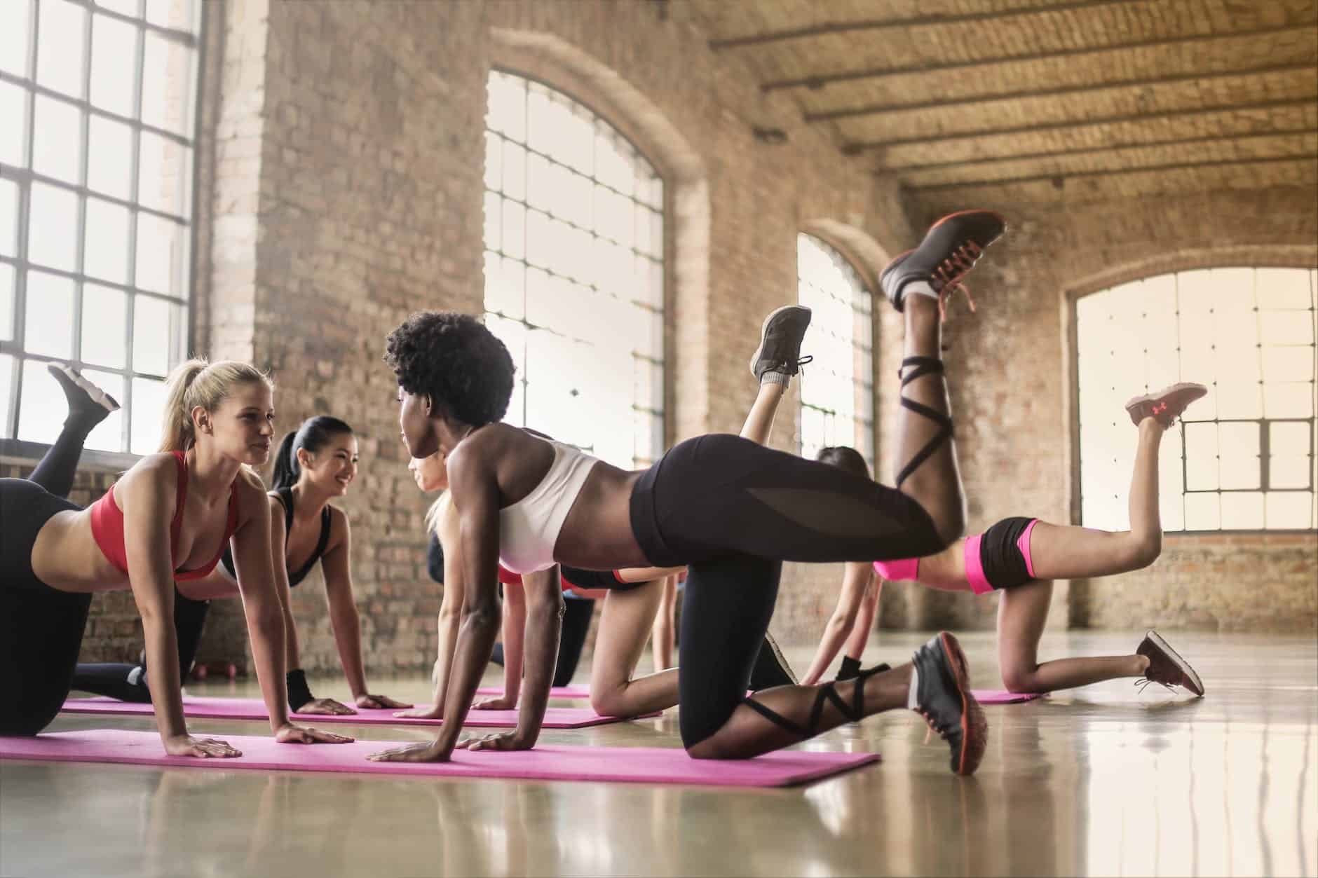 Yoga For Singers 4 women doing yoga class on pink yoga mat